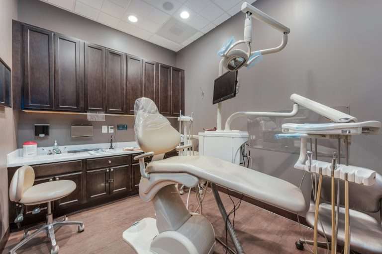 Calm, private operatory at Sacramento Dentistry Group with dark cabinetry and warm lighting